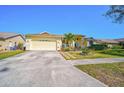Lovely single-story home featuring a manicured lawn, stone walkway, and attached two-car garage at 5565 Sweetwater Oak Dr, Sarasota, FL 34232