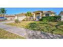 Beautiful single-story home with lush front lawn, mature landscaping, and a charming entrance with a decorative front door at 5565 Sweetwater Oak Dr, Sarasota, FL 34232