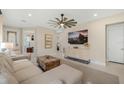 Open-concept living room with a neutral color palette, sleek entertainment center, and seamless flow to other areas of the home at 6239 Baywood Ct, Bradenton, FL 34211