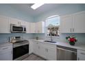 Updated kitchen with white cabinets, stainless steel appliances, and a view from the arched window at 656 Vallance Ne Way, St Petersburg, FL 33716