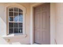 Close-up of a stylish front door with sidelight window, showcasing the home's exterior details at 7432 Birds Eye Ter, Bradenton, FL 34203