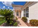 Inviting front entrance with brick walkway, arched windows, and lush landscaping, offering a warm welcome at 7432 Birds Eye Ter, Bradenton, FL 34203