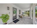Close-up of a quaint front porch with stylish seating, a welcoming wreath, and a 'welcome' door mat at 815 N East Ave, Sarasota, FL 34237