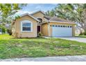 Attractive single-story home featuring manicured landscaping and an attached two-car garage at 1451 Fawnwood Cir, Sarasota, FL 34232