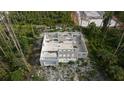 Aerial view of unfinished block home, showing open floorplan in a wooded, partially developed area at 17461 Dudley Ave, Port Charlotte, FL 33954