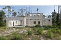 Close up view of cinder block home under construction with garage, window, and door openings in wooded lot at 17461 Dudley Ave, Port Charlotte, FL 33954