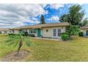 Quaint single-story home featuring lush green landscaping and a vibrant blue-green front door at 1906 Canterbury Ln # 16, Sun City Center, FL 33573