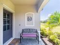 Inviting front porch with a decorative bench and charming decor detail, perfect for enjoying a quiet moment outdoors at 2016 Bonito Way, Port Charlotte, FL 33953