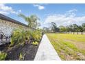 A lush backyard featuring tropical landscaping and a stone walkway with a sprawling green space at 2255 61St St, Sarasota, FL 34243