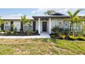Charming home featuring a decorative stone facade, lush landscaping, and a welcoming front entry at 2255 61St St, Sarasota, FL 34243