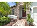 Inviting front entrance with brick walkway, stone facade, and red front door with decorative wreath at 2334 50Th Street E Cir, Palmetto, FL 34221