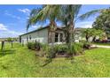 Lush side yard featuring manicured landscaping, beautiful palm trees, and a rod iron fence around the home at 2334 50Th Street E Cir, Palmetto, FL 34221