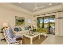 Bright living room with a white sofa, decorative pillows, and large windows at 26687 Raphis Royale Blvd, Englewood, FL 34223