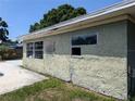 Exterior shot of the home with boarded-up windows and a damaged wall at 3646 Lakewood Dr, Sarasota, FL 34232