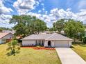 Charming single-story home with a well-manicured lawn, mature trees, and an attached garage at 4155 Center Gate Blvd, Sarasota, FL 34233