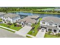 Aerial view of a beautiful home next to a lake and golf course surrounded by lush greenery at 4430 Pond Brook Ct, Bradenton, FL 34211