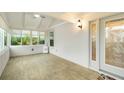 Bright sunroom with tile floors, multiple windows, ceiling fan and decorative front door at 4629 Whirlaway Dr # B, Sarasota, FL 34233