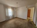 Dining room with outdated carpet and a vintage chandelier at 5114 36Th Avenue W Dr, Bradenton, FL 34209