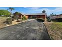 Spacious driveway leading to a single-story home, showcasing the front yard's mature landscaping at 5114 36Th Avenue W Dr, Bradenton, FL 34209
