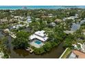 A luxury waterfront home featuring a pool, private dock and lush tropical landscaping at 512 Treasure Boat Way, Sarasota, FL 34242