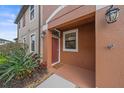 Charming front entrance featuring a red door, lantern lighting, and lush landscaping at 5191 78Th St E Cir, Bradenton, FL 34203