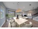 Bright living room and dining area with stylish chandelier and wood look tile floors at 5191 78Th St E Cir, Bradenton, FL 34203