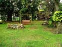 Serene backyard featuring a swing, rock formation, string lights, and mature trees creating a relaxing outdoor space at 5439 3Rd E St, Bradenton, FL 34203