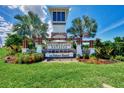 Community entrance with a decorative monument, lush landscaping, and clear signage for Promenade Estates at 5659 Woodland Sage Dr, Sarasota, FL 34238