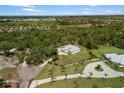 An aerial perspective of a property enveloped by lush trees, showcasing privacy and a long driveway at 601 Suffolk Cir, Nokomis, FL 34275