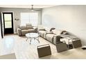 Bright living room featuring modern furniture, neutral tones, and wood-look tile flooring at 6400 46Th N Ave # 113, Kenneth City, FL 33709