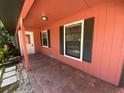 Covered porch with brick flooring and great windows with dark shutters at 6923 13Th E Ave, Bradenton, FL 34208