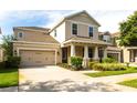 Inviting two-story home showcasing a spacious driveway, covered porch with stately columns, and manicured front yard at 7113 Park Tree Dr, Tampa, FL 33625
