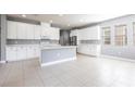 Spacious open kitchen with white cabinetry, stainless steel appliances, a kitchen island, and tile flooring at 7113 Park Tree Dr, Tampa, FL 33625