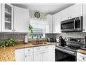 Modern kitchen featuring white cabinets, stainless steel appliances, and granite countertops at 8638 Bessemer Ave, North Port, FL 34287