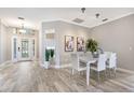 Dining area with table set for six, modern art, and wood-look tile flooring at 8640 Stone Harbour Loop, Bradenton, FL 34212