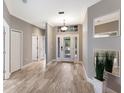 Inviting foyer with wood-look tile flooring, decorative mirrors and a glass front door at 8640 Stone Harbour Loop, Bradenton, FL 34212