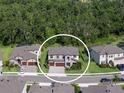 An aerial view of a suburban home shows the home's placement within the community and its proximity to wooded areas at 8932 Isabella Cir, Parrish, FL 34219