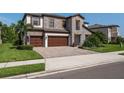 Beautiful two-story home featuring a stone facade, a three-car garage, and tropical landscaping at 8932 Isabella Cir, Parrish, FL 34219