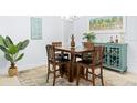 Bright dining area with wooden table and chairs, accented with a tropical painting and décor at 9229 52Nd E Ave, Palmetto, FL 34221