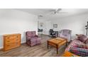 Open living room features wood floors, access to other living areas, and neutral-colored walls at 928 Pineland Ave, Venice, FL 34285