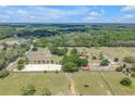 Expansive aerial view of the property with horse arena, pastures, and surrounding trees at 12714 Tyler Run Ave, Odessa, FL 33556