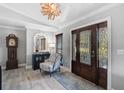 Elegant foyer with wood-look floors, stylish mirror, and glass-paneled double doors at 16918 Waterline Rd, Bradenton, FL 34212