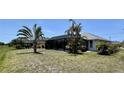 Lush backyard featuring a screened-in pool, mature palm trees, and plenty of room for recreation at 217 Mariner Ln, Rotonda West, FL 33947