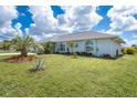 A well-maintained house with a lush lawn and landscaping, palm trees, and well-maintained lawn at 217 Mariner Ln, Rotonda West, FL 33947