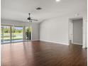 Spacious living room with hardwood floors, ceiling fan, and sliding glass doors that showcase beautiful backyard views at 3415 68Th Street E Cir, Palmetto, FL 34221