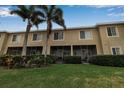 Exterior view of the rear of the townhouse with screened patio, lush lawn and landscaped privacy hedges at 3707 45Th W Ter # 104, Bradenton, FL 34210