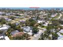 Aerial view of the property, surrounded by mature trees, and Gulf Of America in the background at 417 Park Lane Dr, Venice, FL 34285