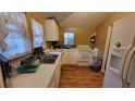 Cozy kitchen with white cabinets, laminate countertops, and wood-look flooring at 4223 Sawyer Rd, Sarasota, FL 34233