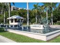 Elegant entrance to L'Ambiance featuring a water fountain, lush greenery, and a guard house at 435 L Ambiance Dr # Ph-J, Longboat Key, FL 34228