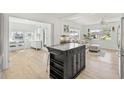 Spacious open concept living room with stylish center island, light wood flooring, and bright interiors at 4519 Brooksdale Dr, Sarasota, FL 34232